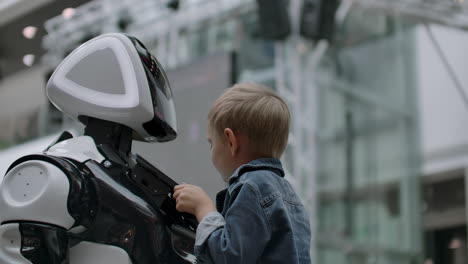 humanoid robot talks with child at technology exhibition. the exhibition park of robots. humanoid robot talks with