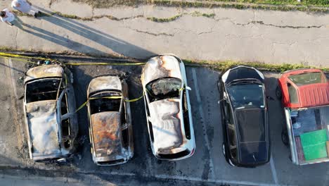 burned cars in a city parking