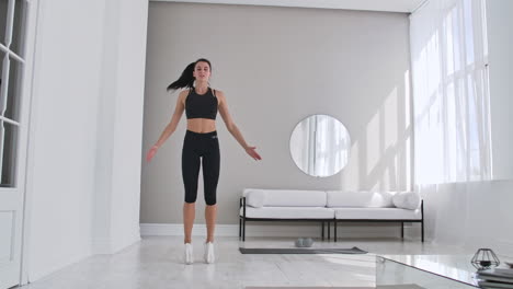 woman doing jumping jacks at home. sportswoman doing jumping jacks exercise at home