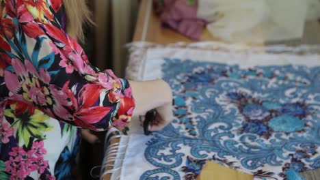 woman sewing or tailoring a fabric scarf