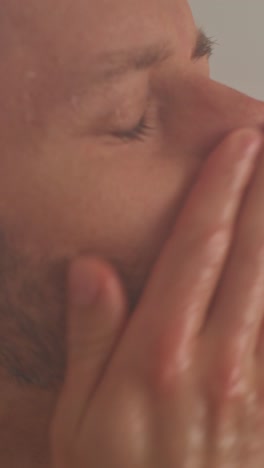 close-up of a man's face and neck in a steamy environment