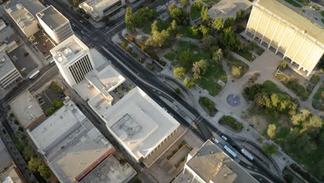 aerial drone footage of a cityscape with buildings, streets, and a park