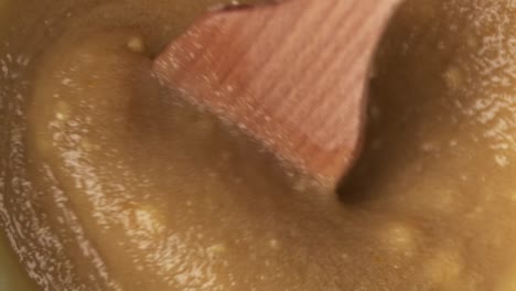 primer plano macro de espátula de madera mezclando delicioso ingrediente de pasta, slomo