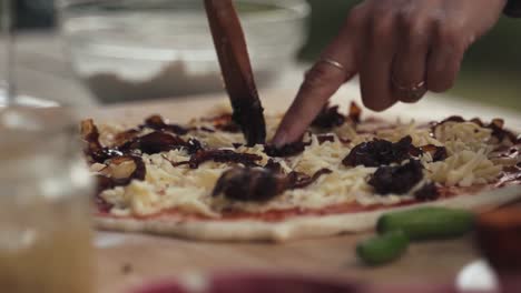 Close-bokeh-shot-of-pizza-being-prepared-at-home-with-cheese-and-onion-toppings