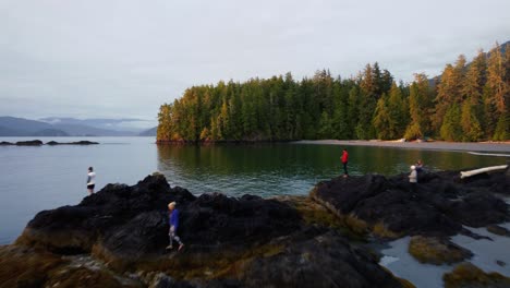 Gorgeous-drone-shot-over-people-watching-the-sunset-on-rocks