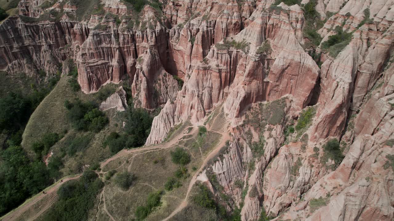 Cinematic pullout ascending drone shot of red cliffs of Rapa Rosie in Romania