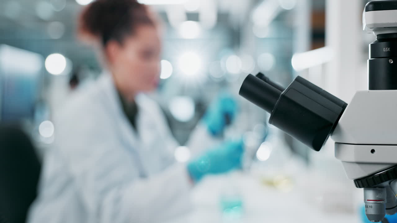 A woman uses a microscope in a laboratory
