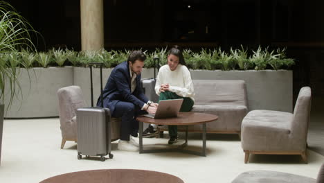 personas de negocios usando sus portátiles en el pasillo del hotel