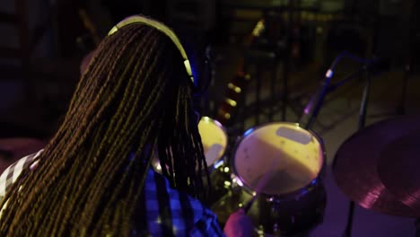 Man-with-dreadlocks-playing-drums-in-a-music-studio