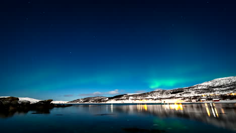 home lights and dreamlike aurora borealis reflected in skogsfjord, time-lapse