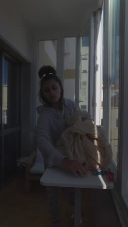 woman drying clothes on balcony