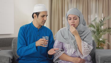 muslim husband giving medicine to his wife