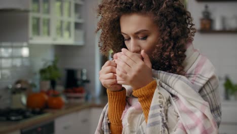 Worried-woman-wrapped-in-a-blanket-drinking-hot-tea/Rzeszow/Poland