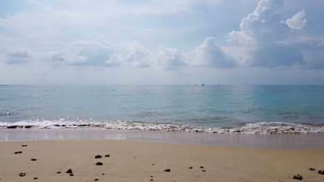 landscape view of the white sea sand beach in summer daytime with some wave and wind blowing in phuket, thailand - in slowmotion 4k uhd video