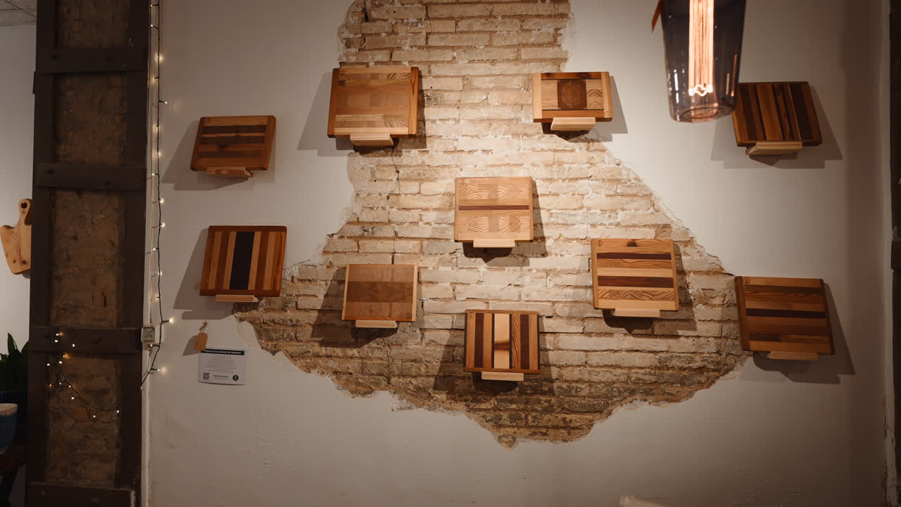 Tablas de cortar de madera expuestas en una pared rústica de ladrillo visto