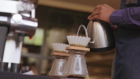 primer plano hombre vertiendo agua caliente en la máquina de café para preparar café en el restaurante