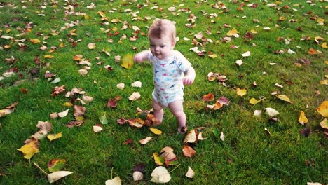 happy toddler takes first steps unassisted in grass field full of leaves