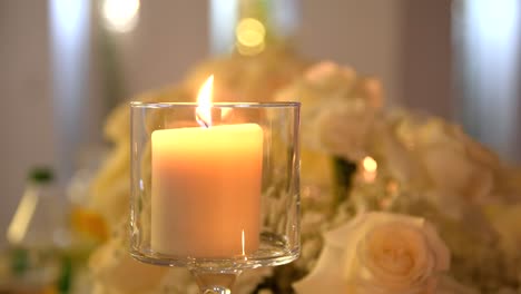 burning candle in a glass container as a table decoration