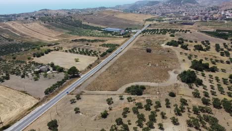 Aerial-view-of-rural-sicilian-road-with-cars-in-countryside-of-Sicily-during-beautiful-sunny-day