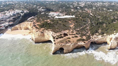 Antena,-Revelación-De-Retroceso,-Imágenes-De-Drones-De-Los-Acantilados-únicos-Y-Formaciones-Rocosas-A-Lo-Largo-De-La-Costa-Cerca-Del-Pueblo-Costero-De-Benagil,-Portugal