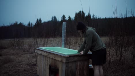 un hombre con una bañera de baño caliente diy en la naturaleza al aire libre