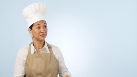 mujer asiática feliz, chef y apuntando a la maqueta