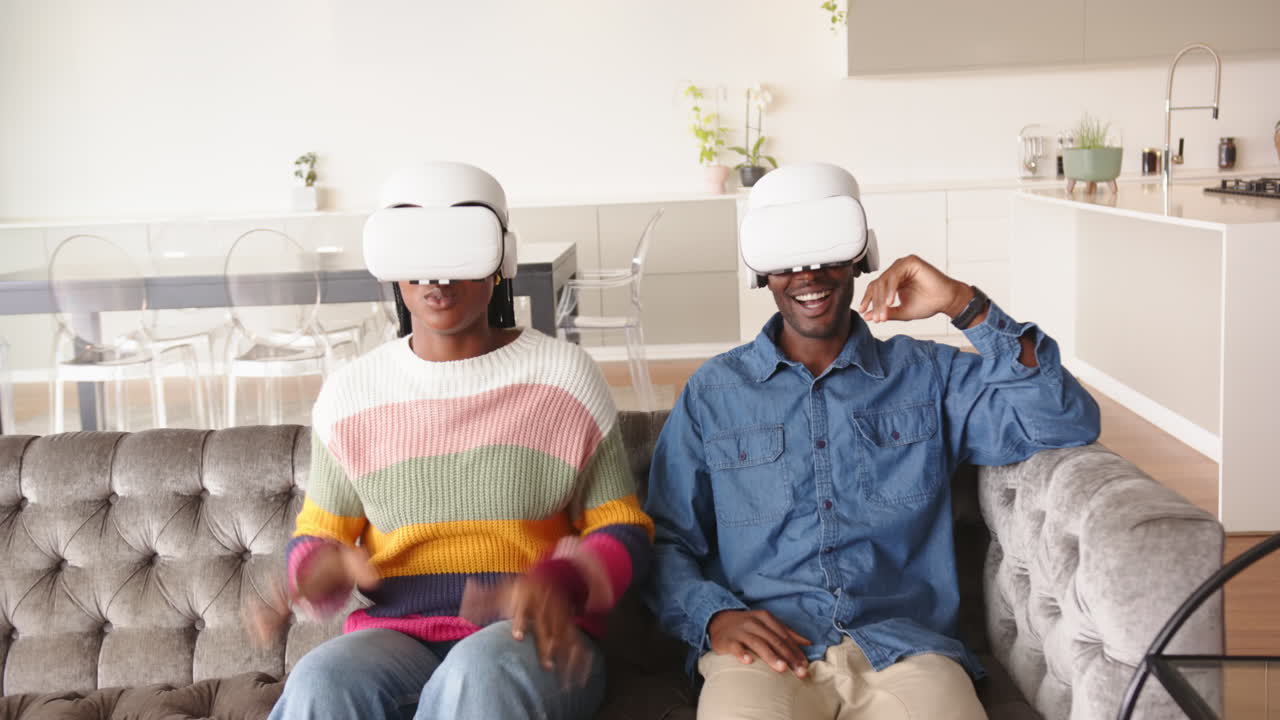Using vr headsets, young african american couple on couch and enjoying virtual reality, at home