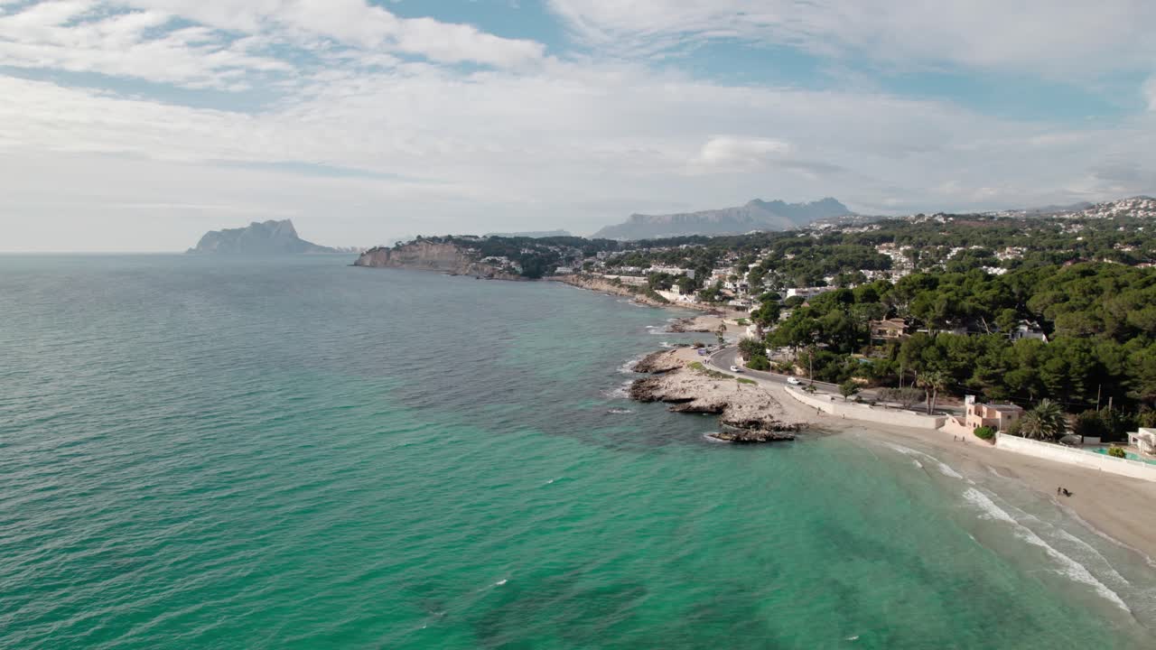 Turquoise Waters And Rocky Coastline Near Ampolla Beach In Moraira, Alicante, Spain. aerial shot