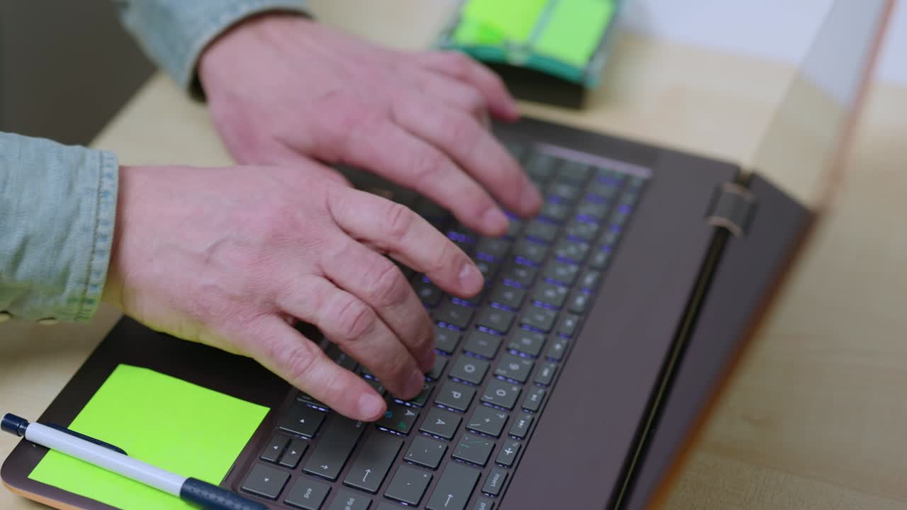 una vista de cerca de las manos de un hombre escribiendo en el teclado de la computadora. suecia.