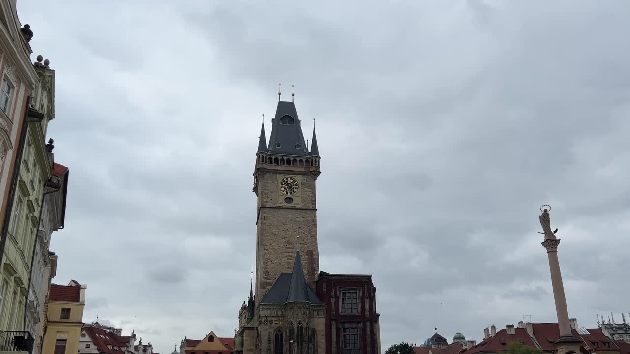 Prague Old Town Square showing the historic clock tower, traditional European buildings and cloudy sky. Iconic landmark and heritage architecture
