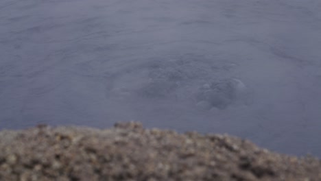 dark blue boiling mud pool with steam at myvatn geothermal area, iceland