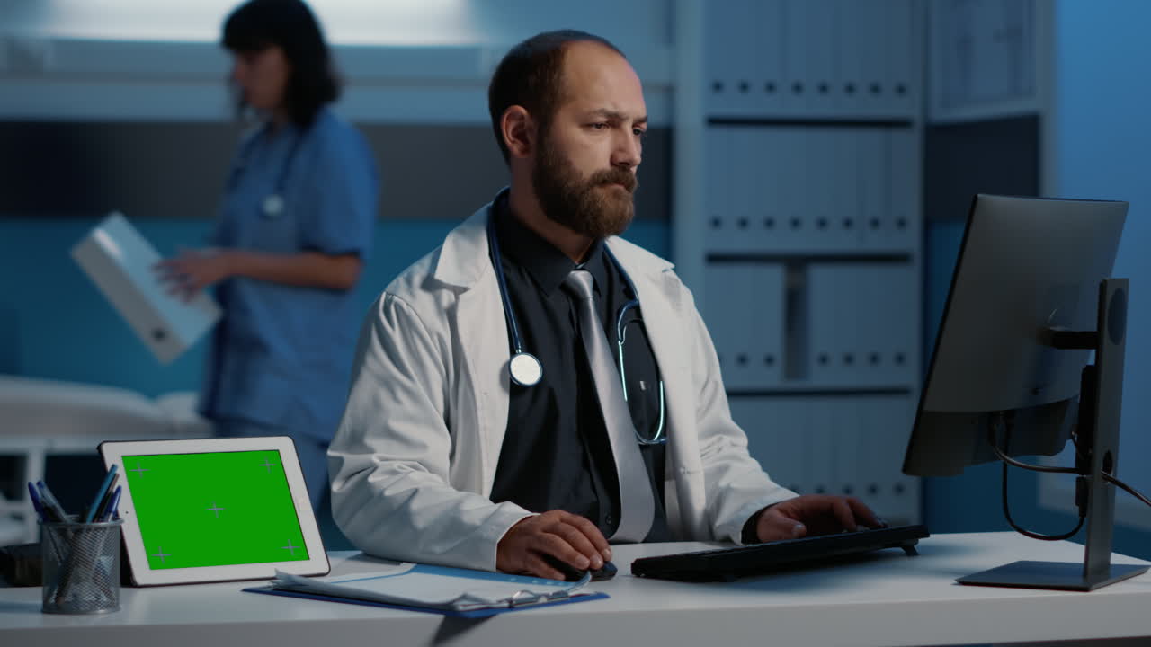 Doctor working at desk with green screen tablet