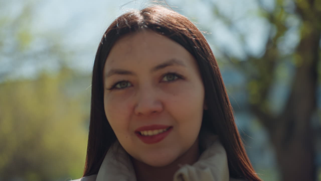 Una persona annusa dei fiori mentre osserva le caratteristiche delle piante alla luce del giorno; una donna esplora le peculiarità delle piante e ne percepisce le fragranze alla luce del sole in un parco, nell'ambito di un'osservazione scientifica.