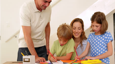 padres y hijos felices dibujando juntos en la mesa