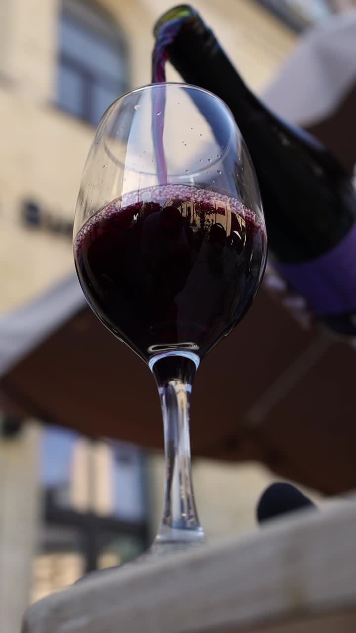 Versare il vino rosso in un bicchiere