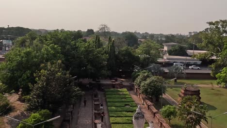 Aerial view of manicured gardens and pathways surrounded by dense greenery in a historical park setting.