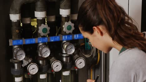 female engineer maintaining record in clipboard