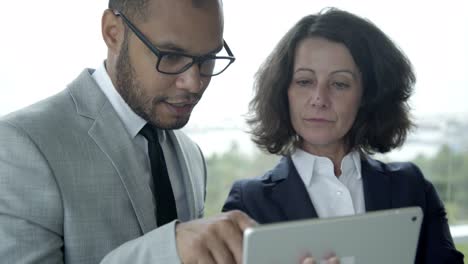 Selbstbewusste-Geschäftsleute,-Die-Ein-Tablet-In-Der-Hand-Halten-Und-Reden