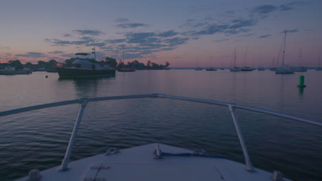 slow-mo of small boats in dock, new york in the evening, pink sky, from the boat