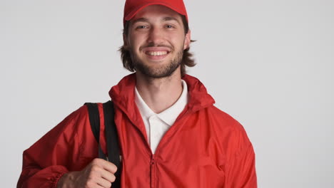 Caucasian-delivery-man-in-front-of-camera-on-white-background.