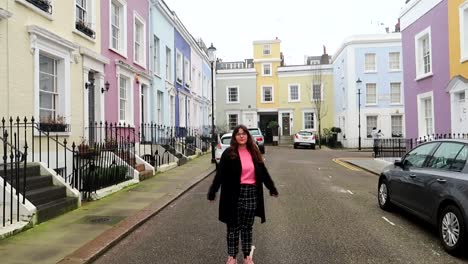 Female-tourist-turning-on-herself-in-the-colorful-streets-of-Notting-Hill,-London