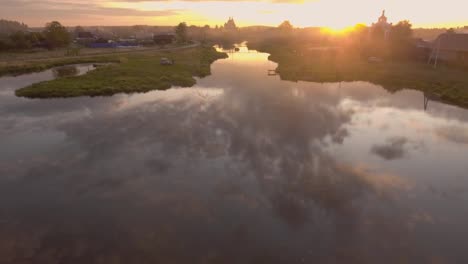 rustic village by river at sunset