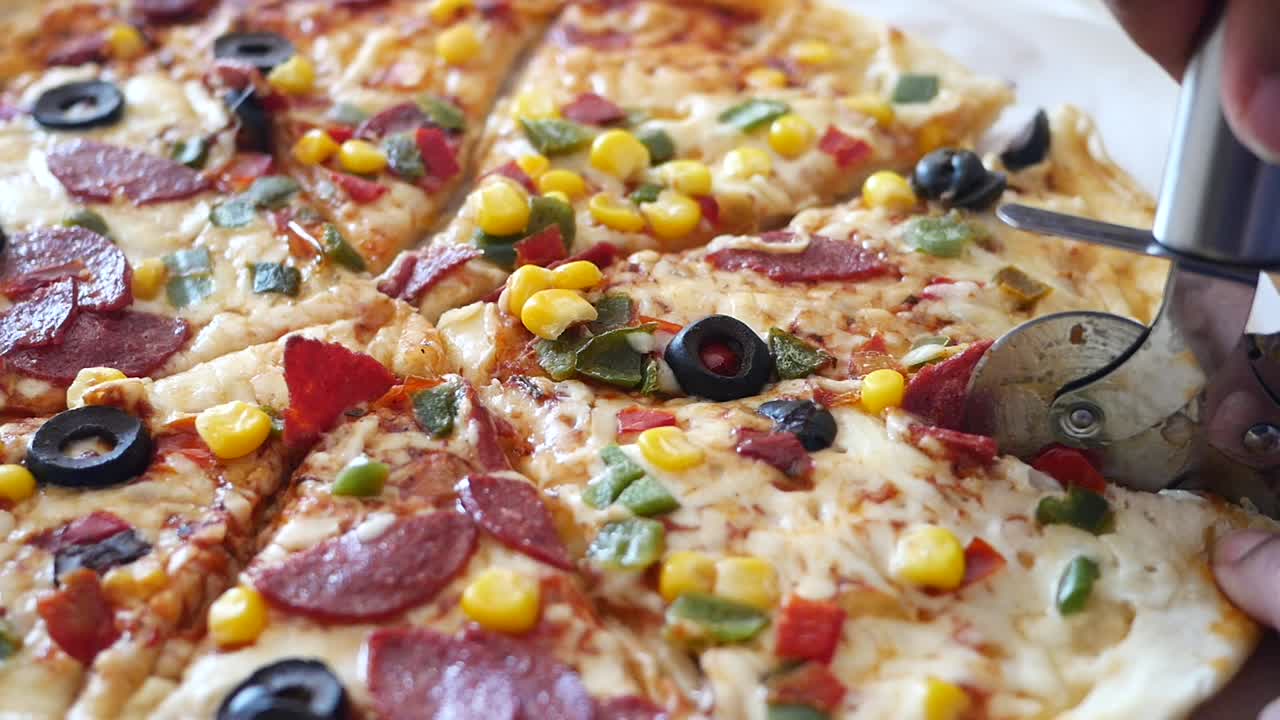 Primo piano di una pizza con salame piccante, mais, peperoni verdi e olive