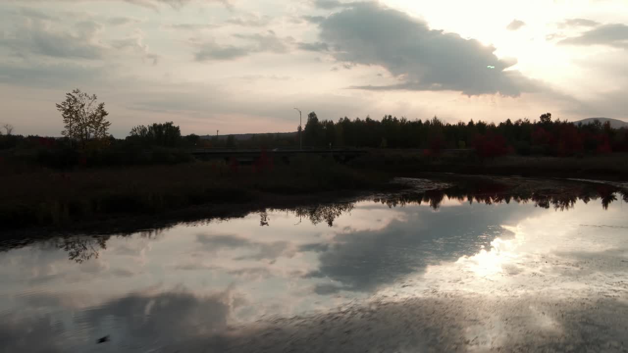 volando sobre las tranquilas aguas del río con reflejos del cielo durante la puesta de sol en magog, quebec, canadá
