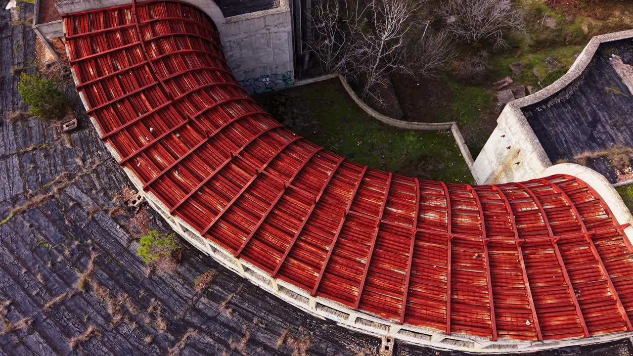 Aerial view of abandoned structure highlighting unique roof design