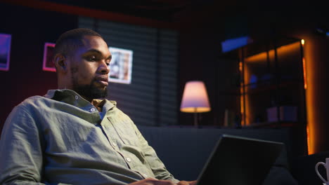 vertical video focused black person multitasking on laptop in stylish loft space