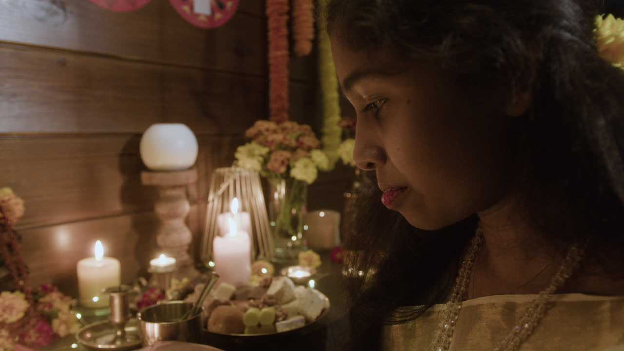 Young Girl Praying with Candles and Flowers