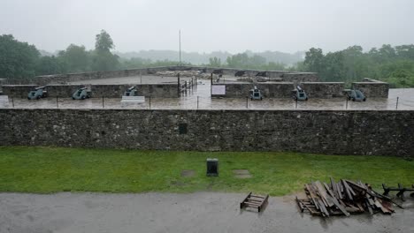 a tilt reveal of the interior of fort ticonderoga as gentle rain falls on the stone walls and canons