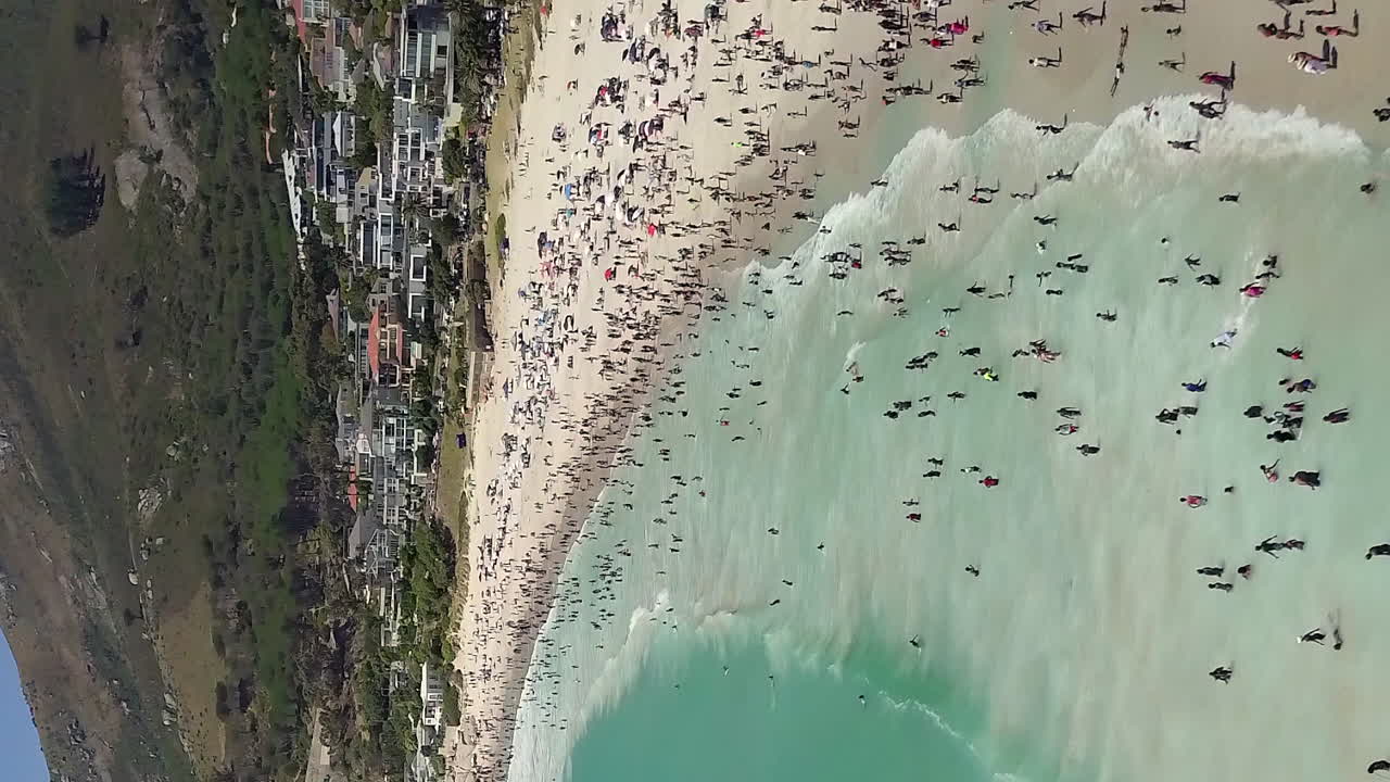 케이프 타운의 캠프 베이, 남아프리카 공화국은 주민들과 관광객들로 붐비고 있습니다 - 수직 공중 비행