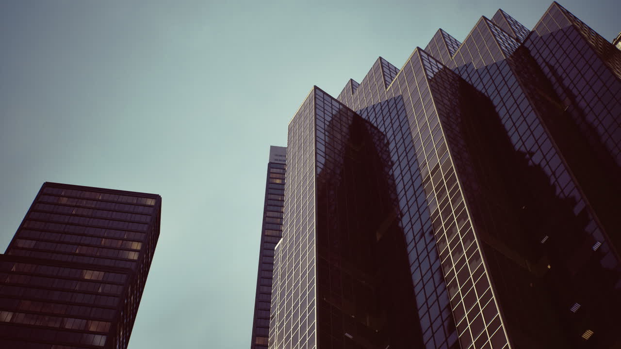 Modern skyscrapers reflect the sky in a city setting during the day
